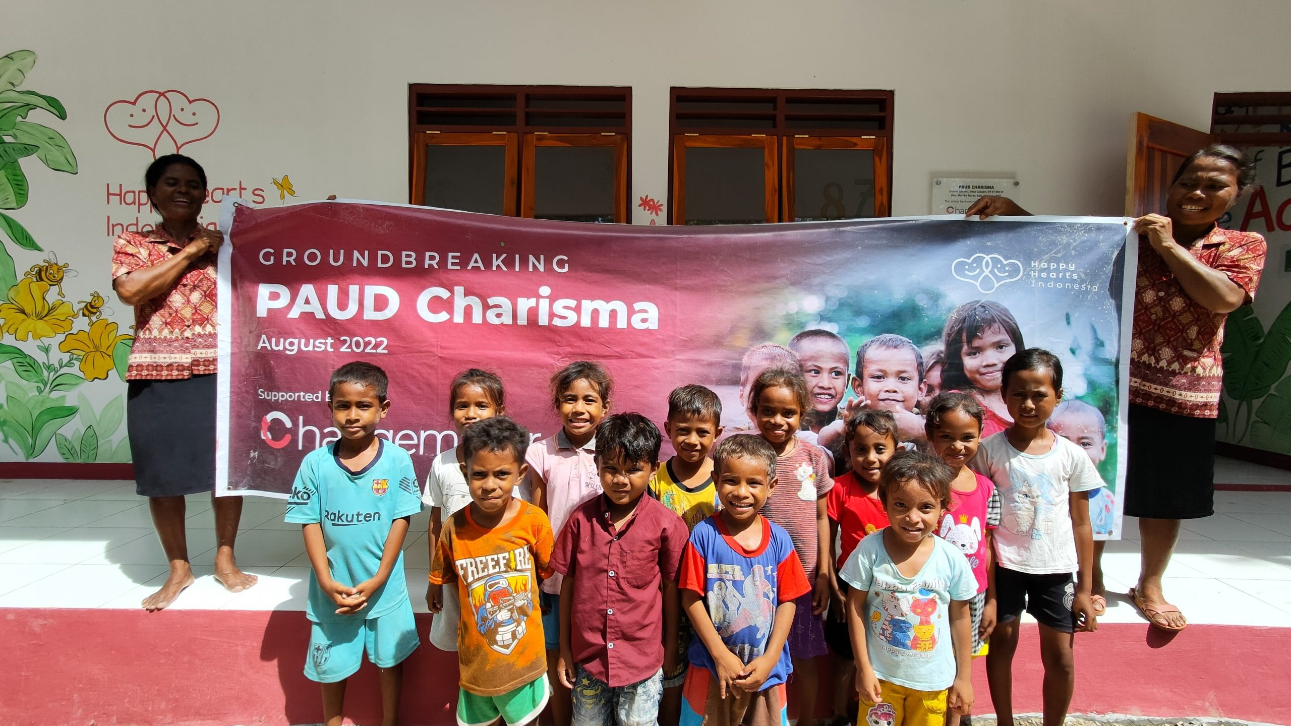 teachers and students standing in front of the monthly donation program banner